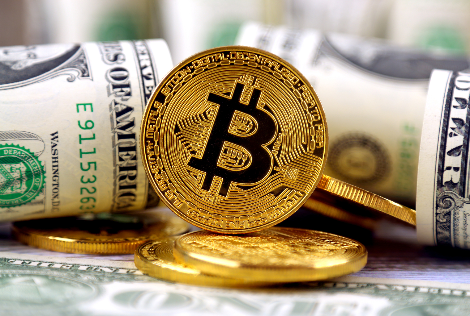 ręce wpychające banknoty dolara do maszyny produkującej monety Bitcoin